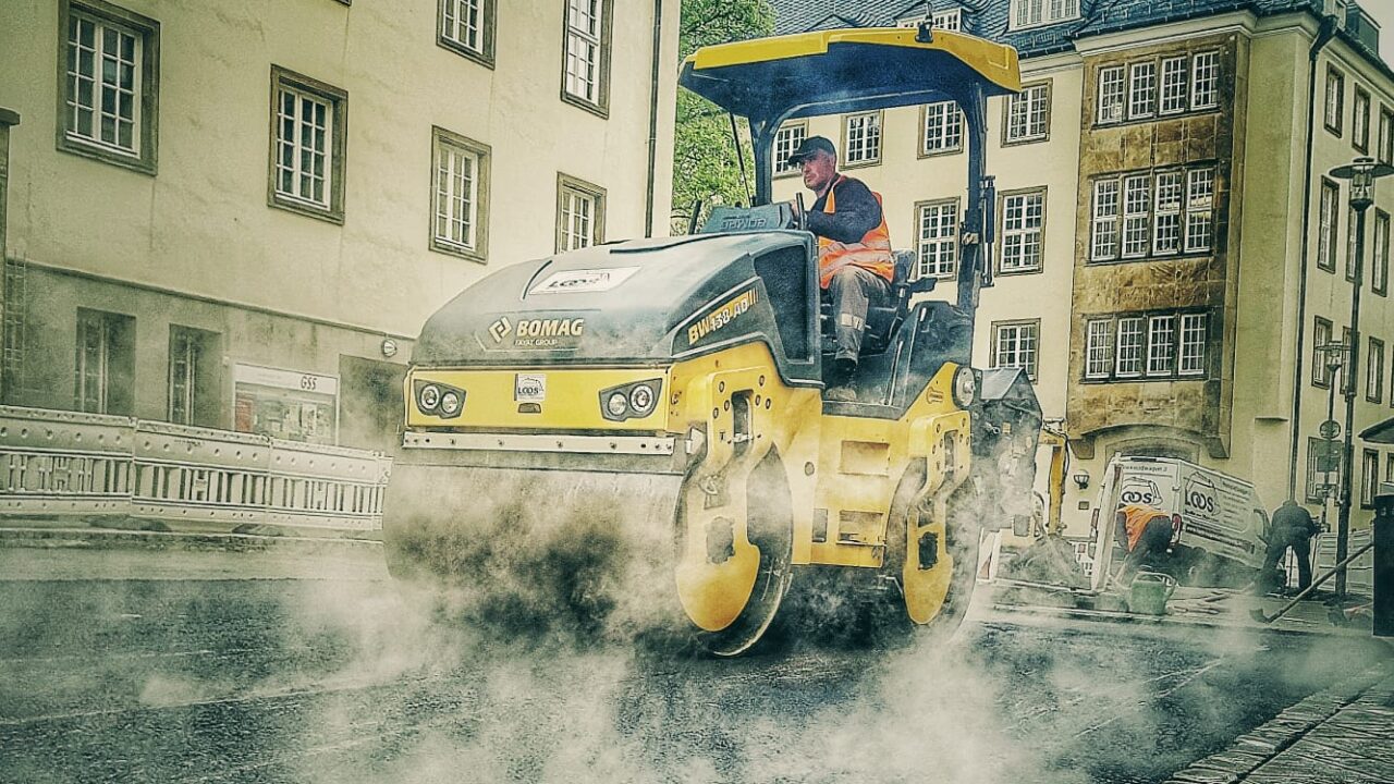 Straßenwalze bei Asphaltarbeiten im innerstädtischen Straßenbau