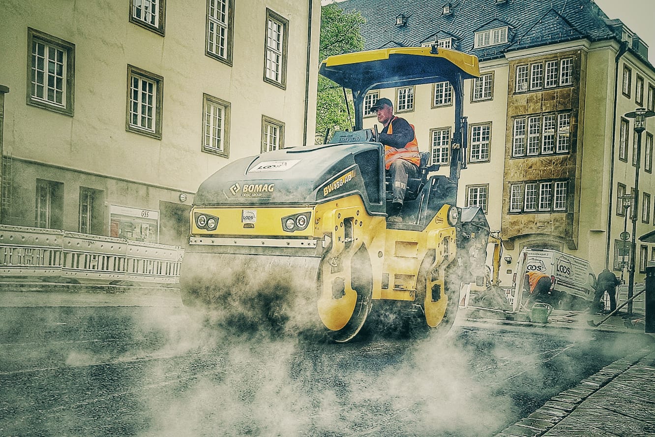 Straßenwalze bei Asphaltarbeiten im innerstädtischen Straßenbau